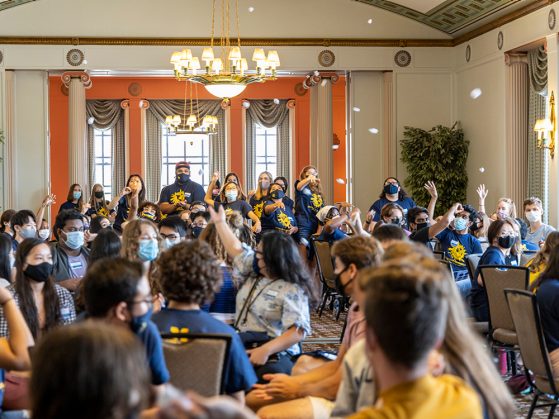 GSP students throw balls of crumpled paper in the air for the “snowball” icebreaker activity at Welcome Orientation