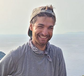 IPAMAA student Joey Frankl standing on hilltop with distant landscape in background