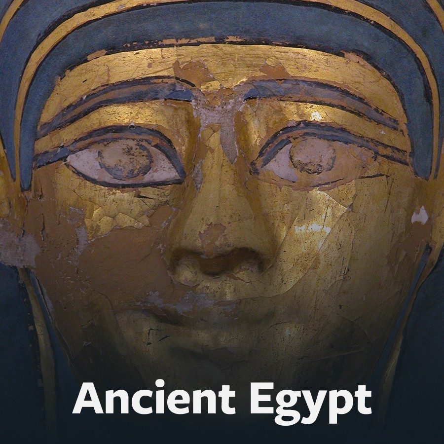 Button to the Ancient Egypt scavenger hunt featuring closeup image of a blue- and gold-painted mummy mask.