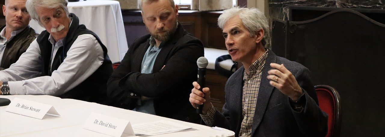 Professor David Stone speaks into a microphone at a panel discussion.