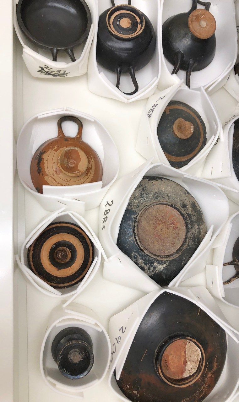 Storage drawer with various ceramic vessels.