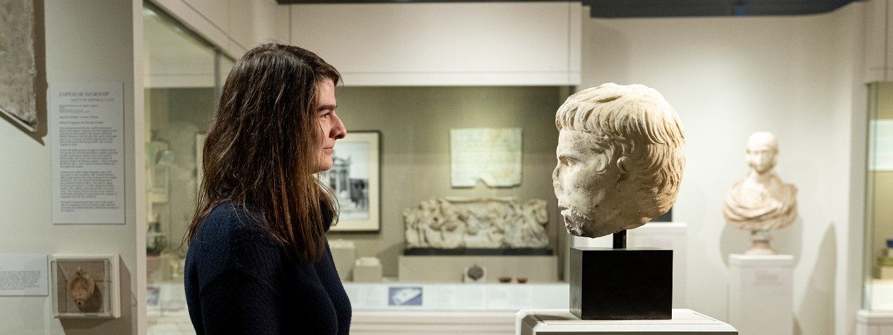 Graduate student Erica Venturo looks at a marble statue of the head of Emperor Augustus in the Kelsey Museum’s galleries.