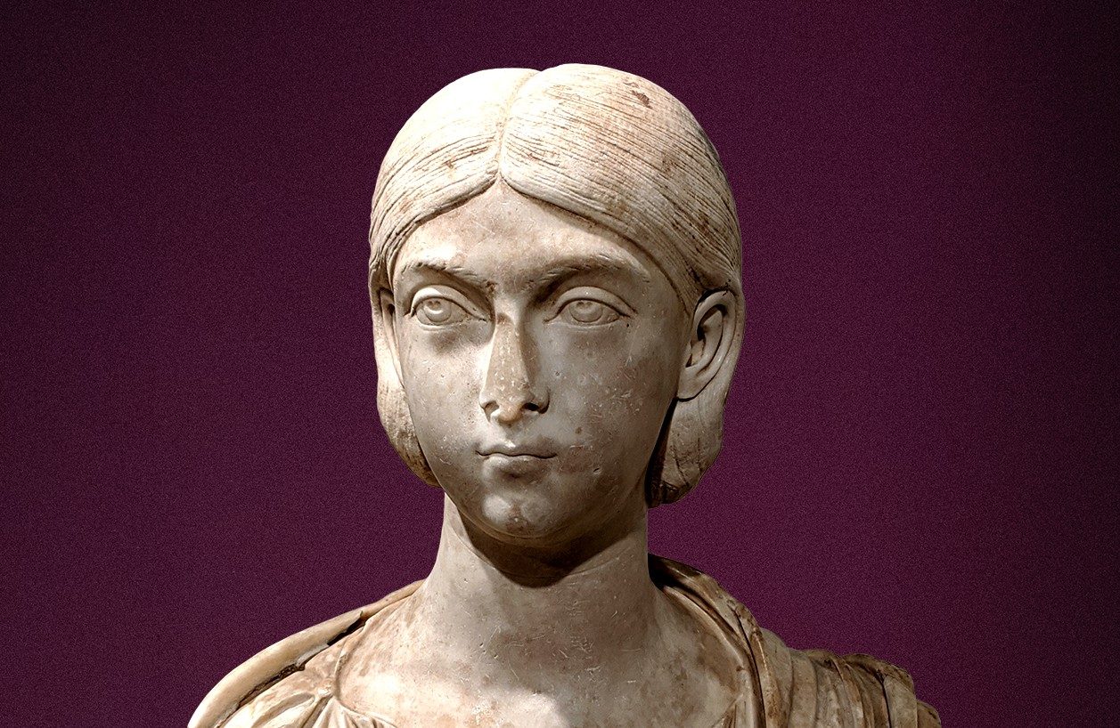 Marble bust of a Roman woman. Her hair is parted down the center and pulled back.
