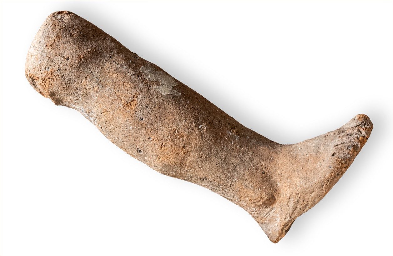 Small ceramic anatomical votive in the shape of a child’s foot and leg.