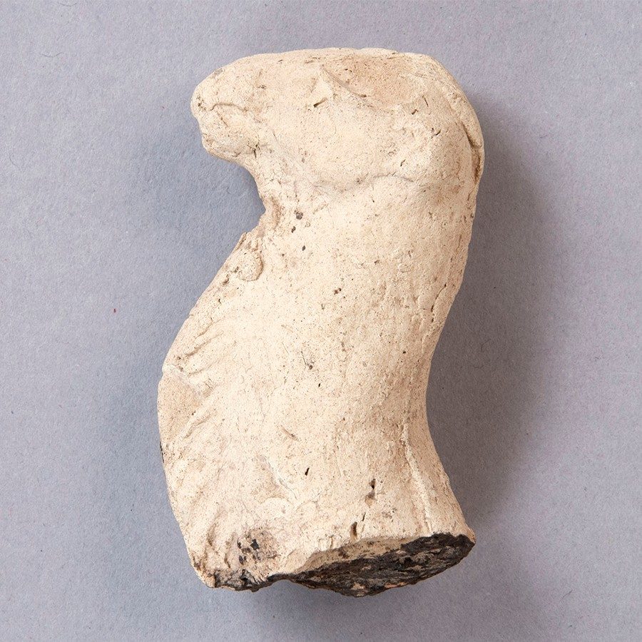 Light tan ceramic fragment shaped into the head and neck of a camel.