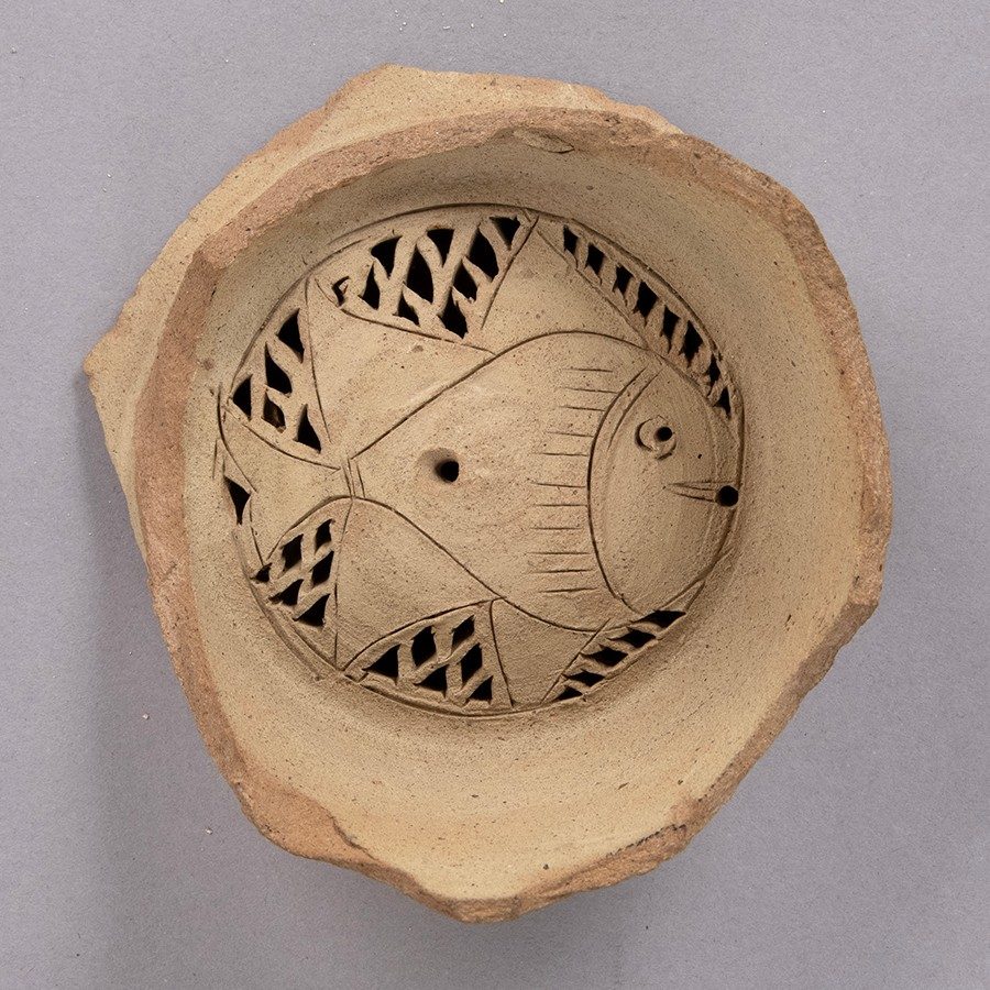 Buff-colored clay water filter with a fish design at the bottom.