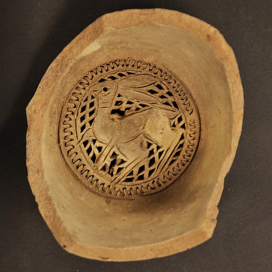 Buff-colored clay water filter with a rabbit design at the bottom.