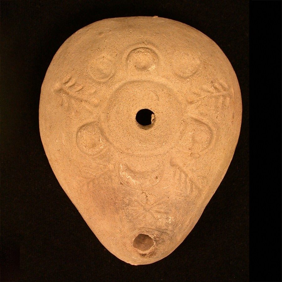 Light tan terracotta oil lamp decorated with lines and circles.