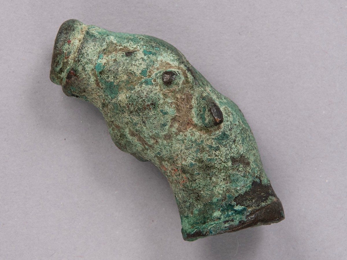 Small, light green water spot with openings at both ends, shaped to resemble a horse’s head.