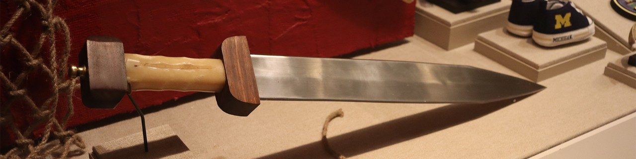 Straight steel blade with a wooden handle.