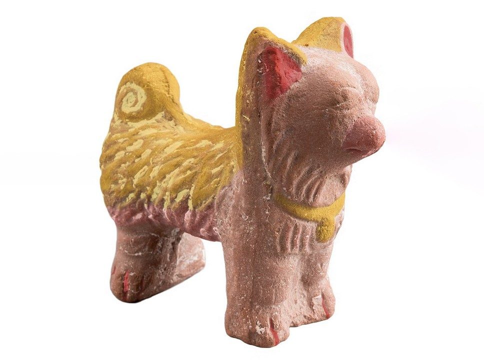 Ceramic dog figurine with pink, red, and yellow color reconstruction.