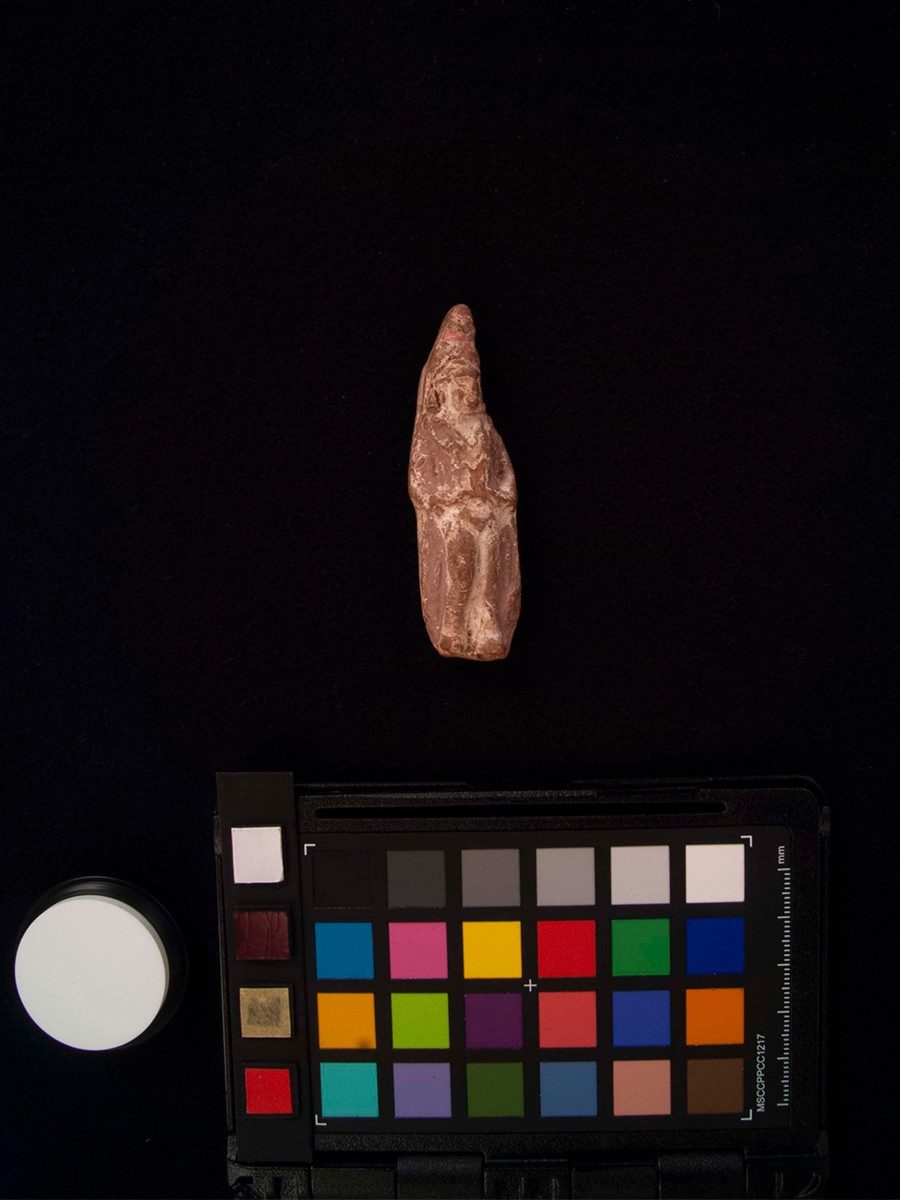Ceramic dog figurine with pink, red, and yellow color reconstruction.