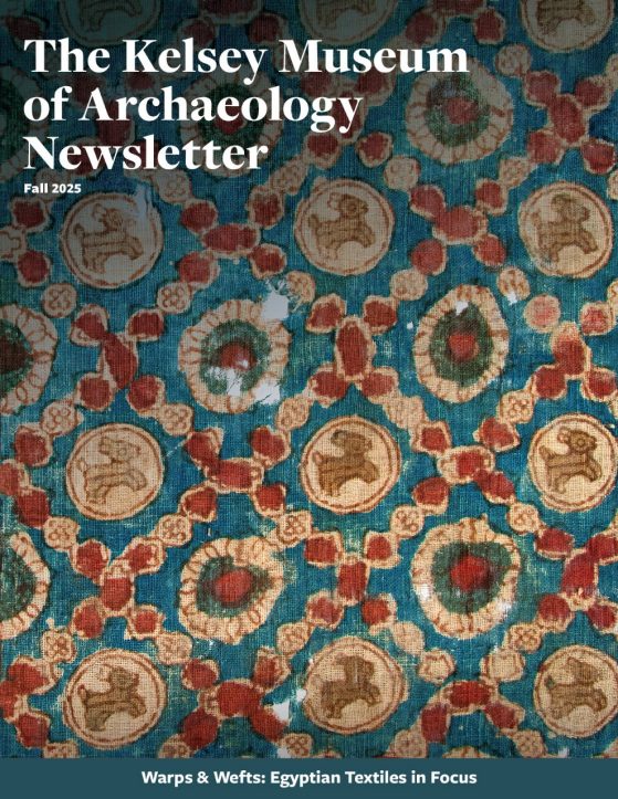 Cover of the Fall 2025 edition of the Kelsey Museum Newsletter. It features a close-up of a Late Antique Egyptian block-printed textile with occasional small frays and holes. The design features small donkeys enclosed in circles, round flowers, and rows of red circles intersecting in diamond patterns in red, tan, brown, and blue. Text across the bottom band reads, “Warps & Wefts: Egyptian Textiles in Focus.”
