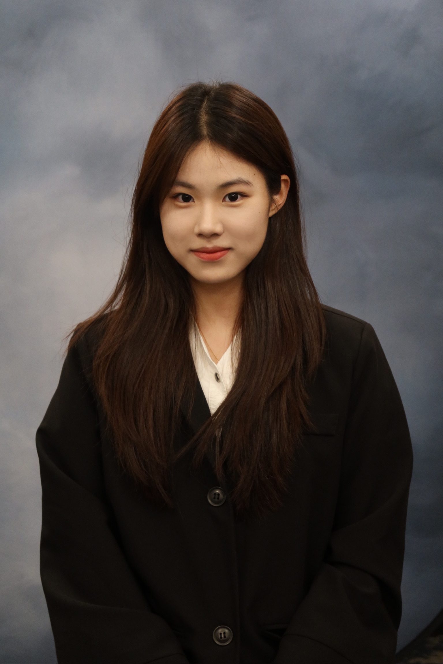 Image of girl standing in front of a gray background.