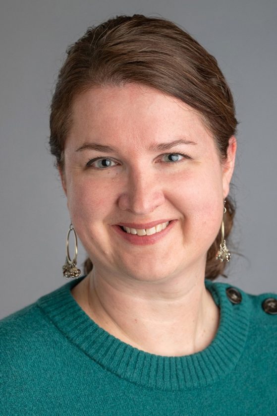 brown-haired woman wearing a green sweater