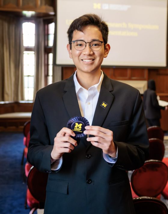 Headshot of Vinh-Dien holding ribbon