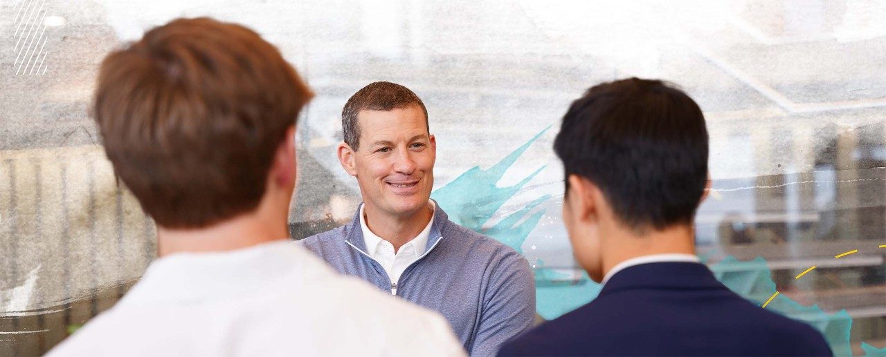 Employer smiling and talking to students