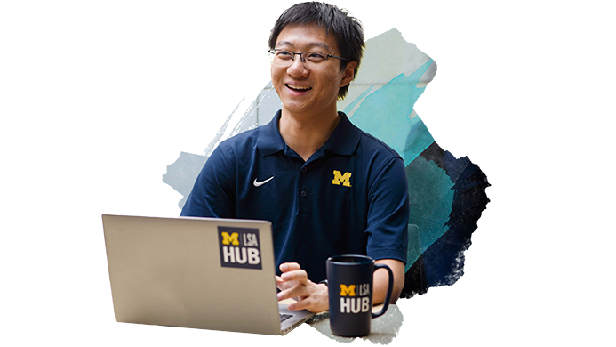 Student working with laptop, smiling and looking off camera
