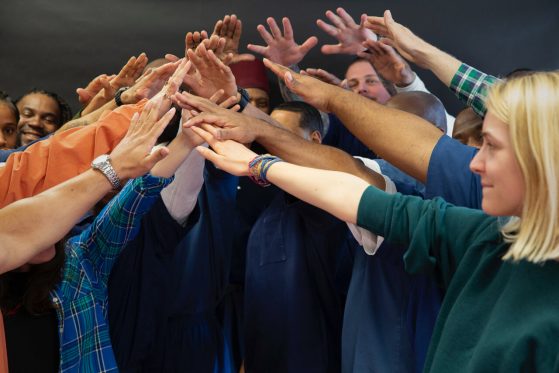 Group of individuals creating a bridge with their hands