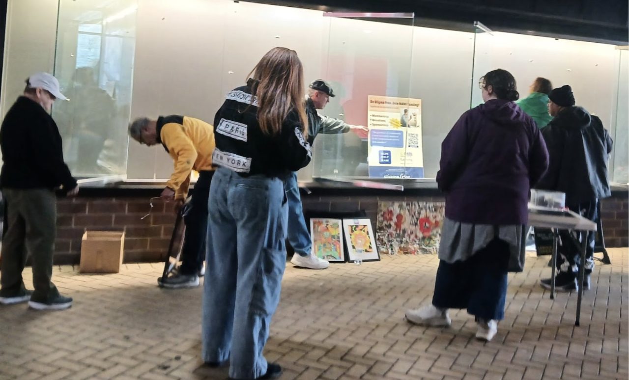 Small group of people admiring artwork on a street