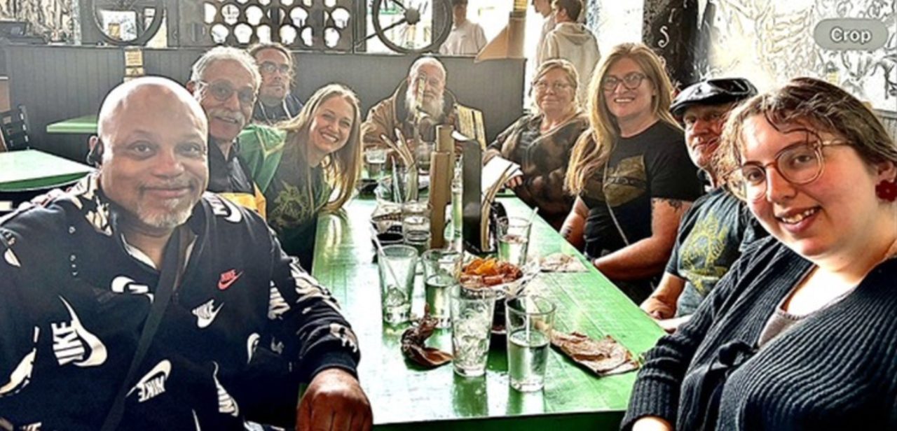 Group of people dining at restaurant, smiling for photo