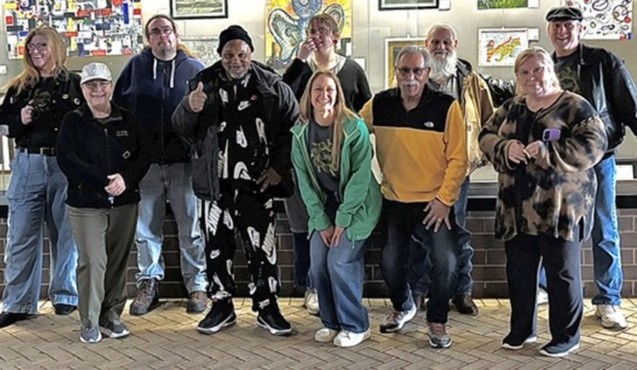 Group of people posing in front of artwork