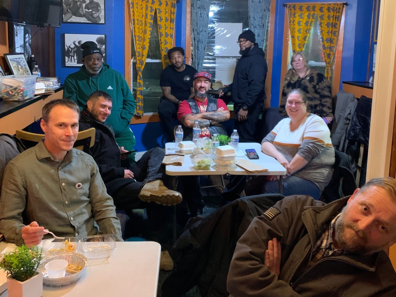 Group of people sitting at tables, smiling