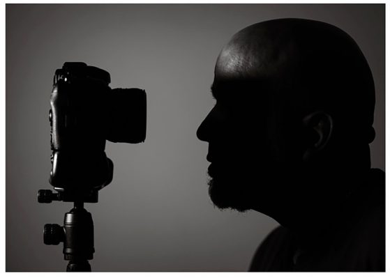 Adolfo Cruz looking into a camera - point of view from the side