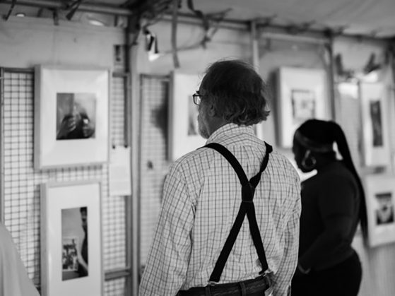 Two people looking at artwork hanging on a wall