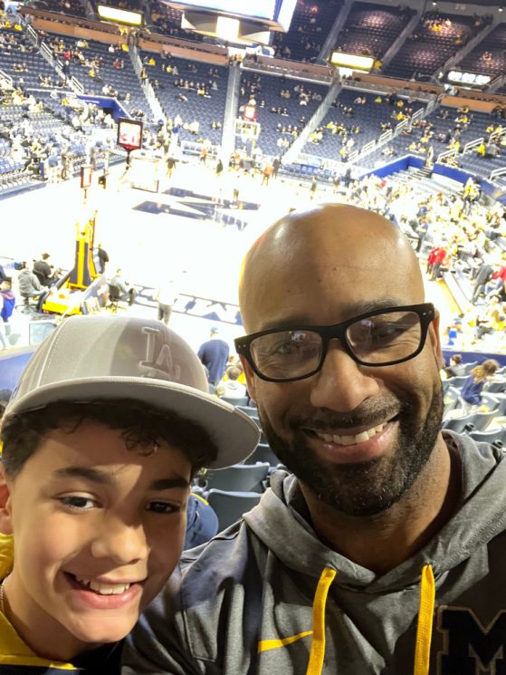 Father and son smiling at U-M basketball game