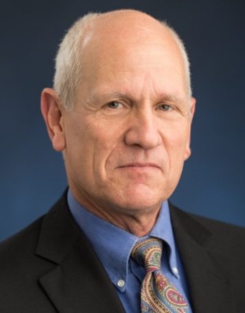 Photo of Professor Timothy Chupp in a blue shirt and black suit with a tie
