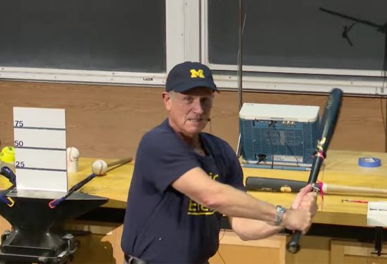 a speaker with a Michigan baseball cap on swinging a torpedo bat