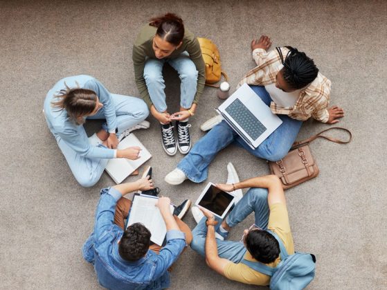 Study, laptop and group of students on floor in project, research or planning, brainstorming and teamwork. Notebook, education and top of university student, friends or people collaboration in school