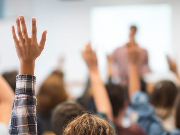 Students actively raising hands in class students engaged in education