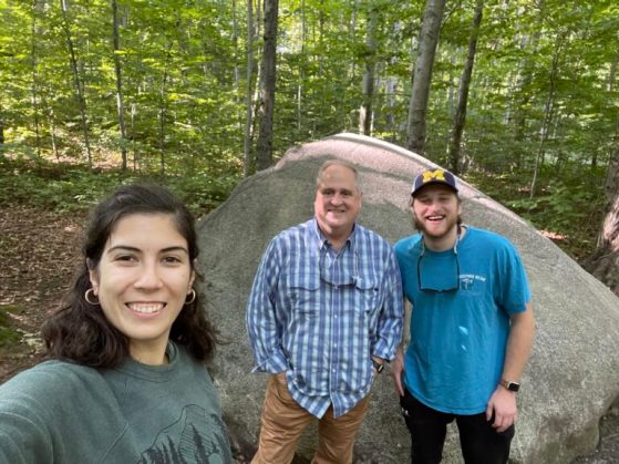 SEAS graduate students smile in a wooded area on Beaver Island.
