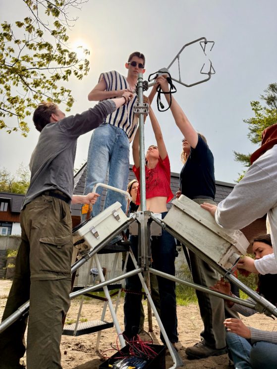 Students putting together a tall structure outside