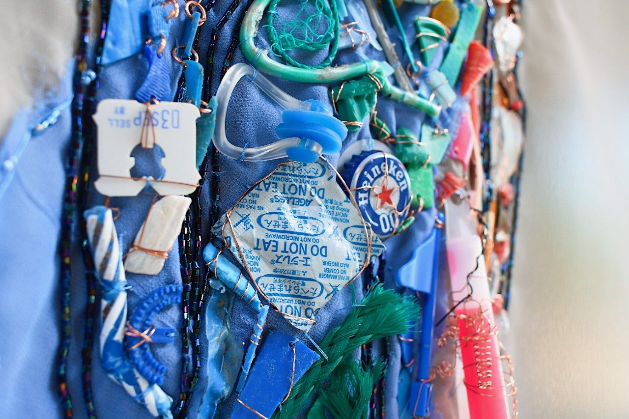 Plastic trash organized as art on a canvas