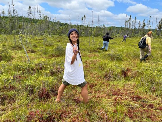 Person walking at a bog giving a peace sign with her fingers