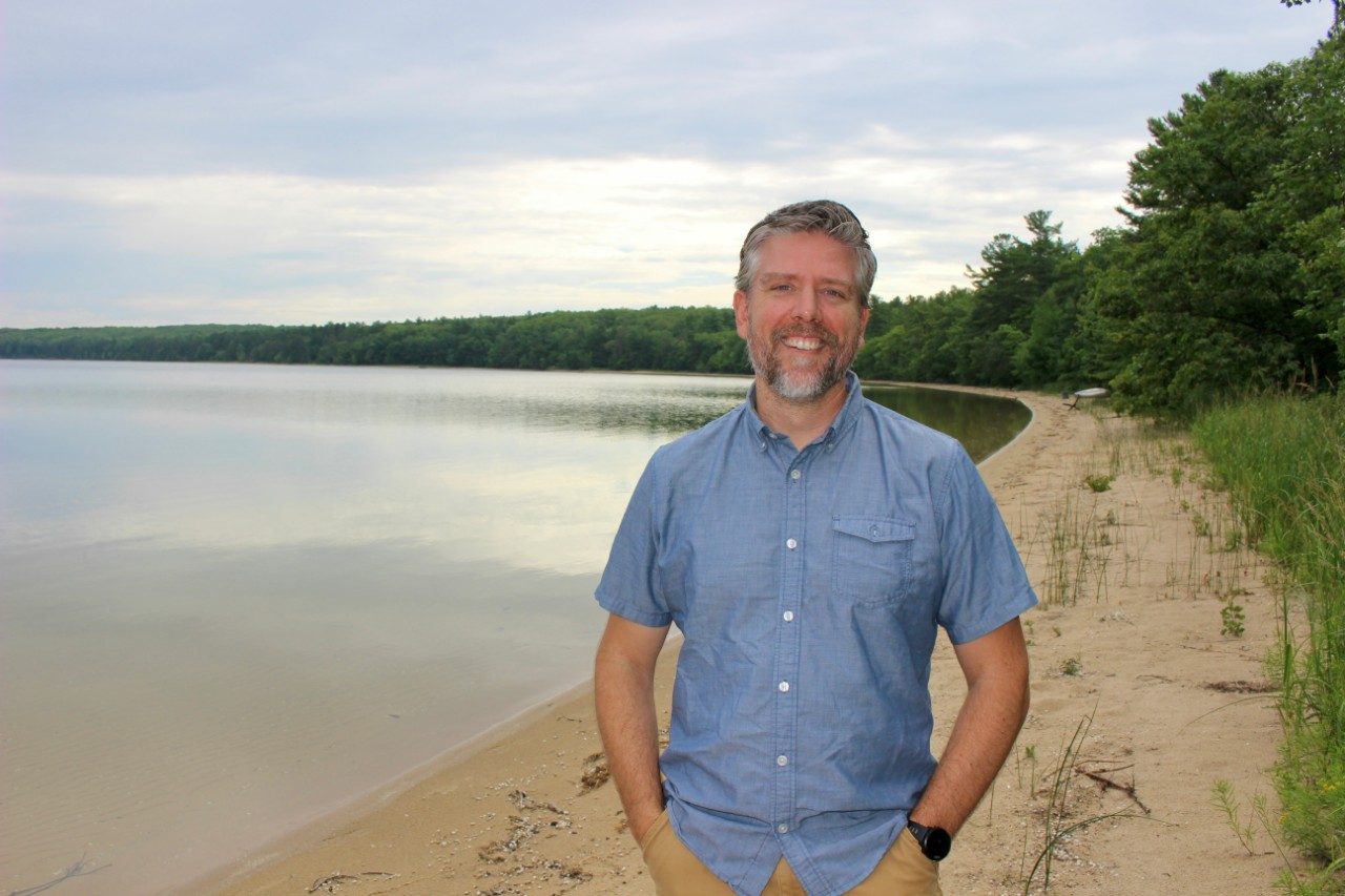 Man standing along a lakeshore