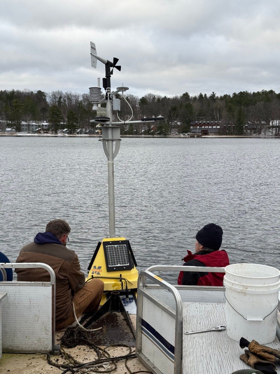 People on a boat next to a buoy