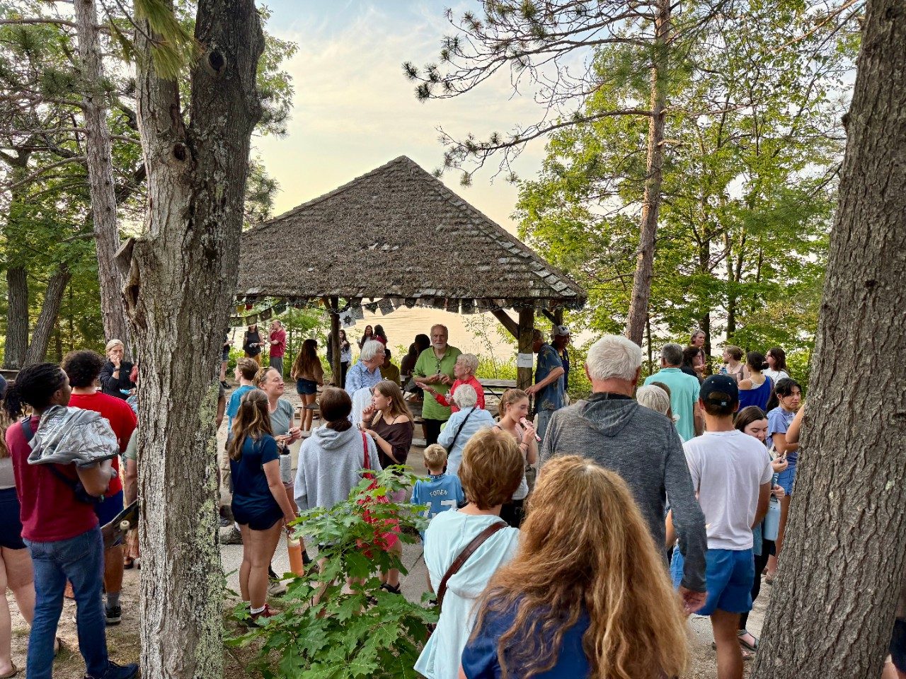 Crowd gathered outside along a lake