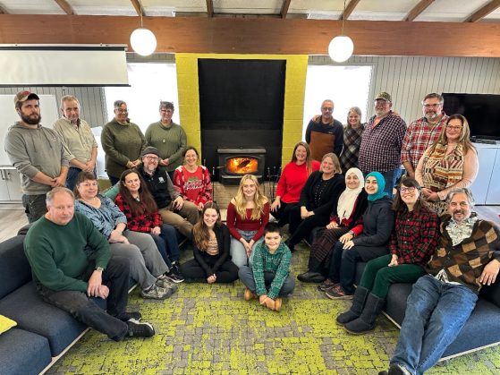 Group of people posing in front of a fireplace