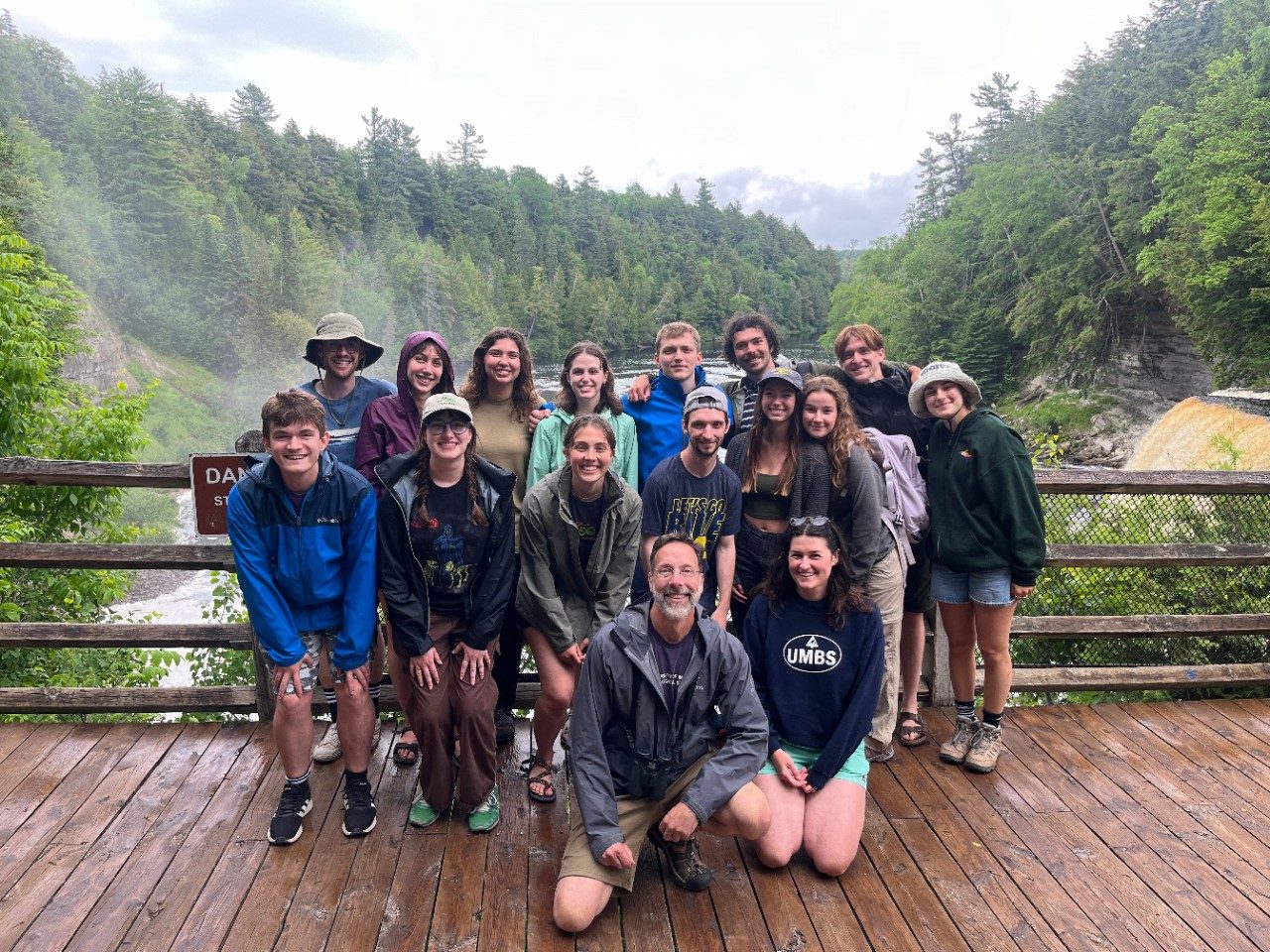 Group photo along a river with a waterfall