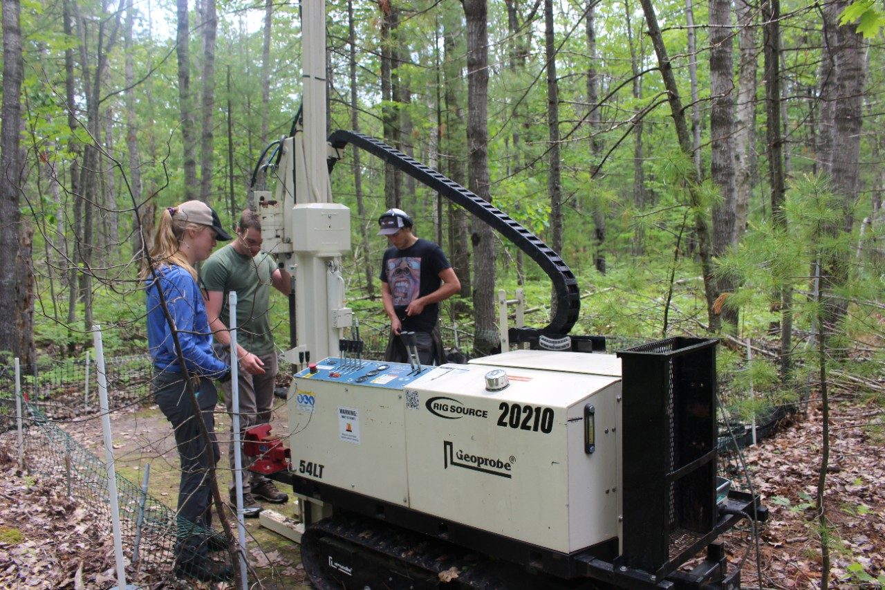 People operating a big machine in a forest