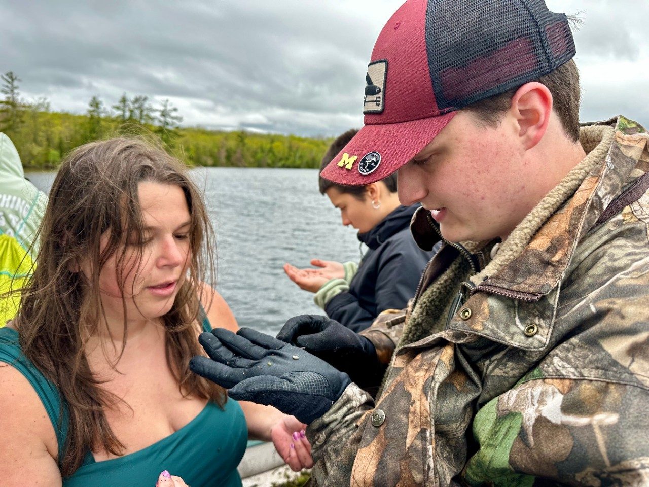 People on a boat looking at an insect 