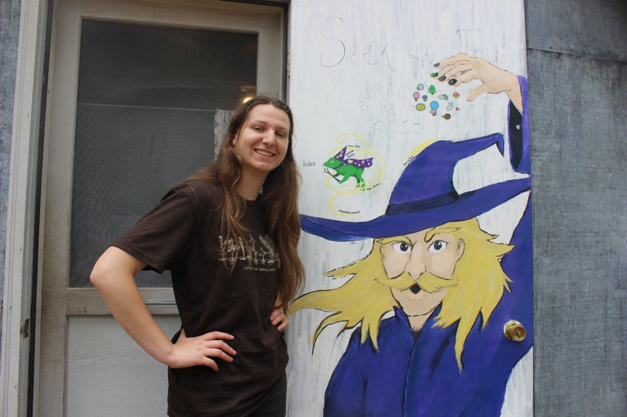 Person standing next to a door with a drawing on it