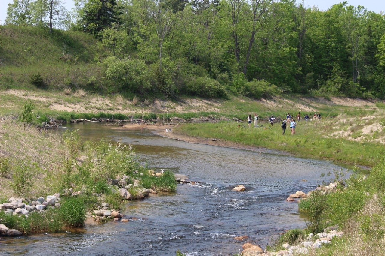 Winding river with people standing along the shore