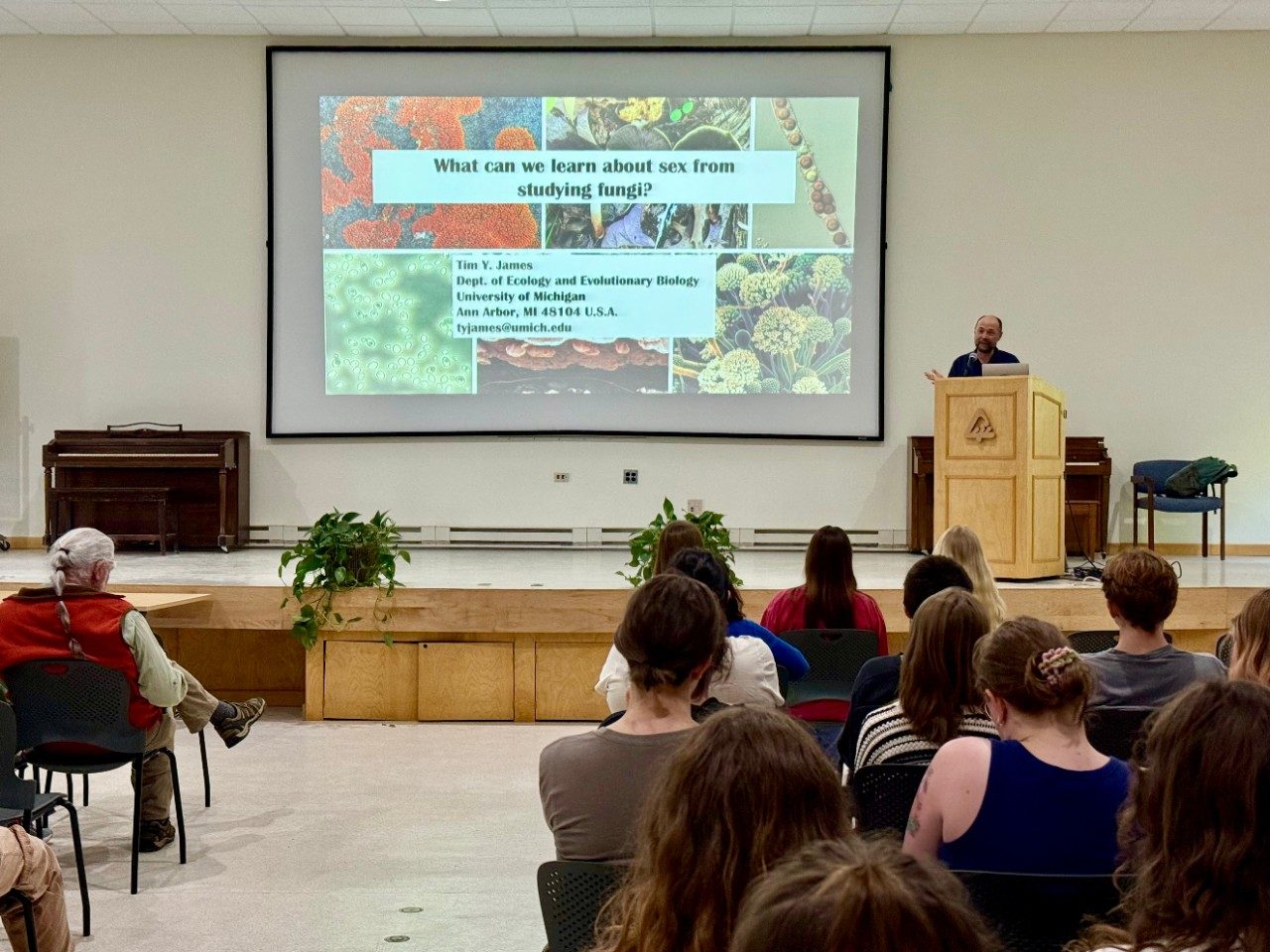 Person giving a lecture in front of an audience