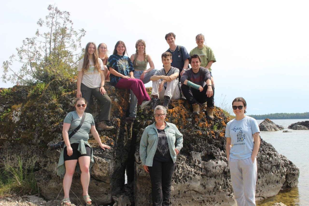Group photo on a massive rock along a lake