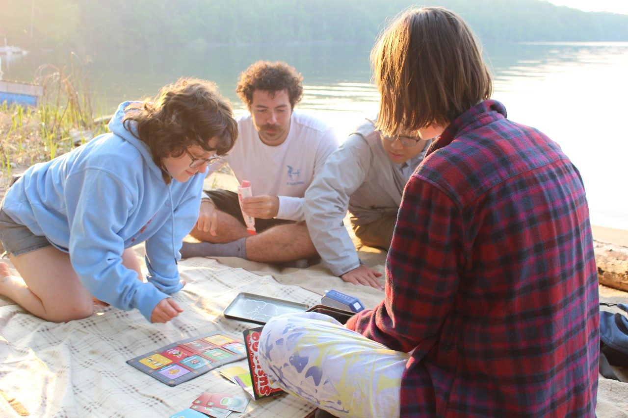 People playing board games on a blanket on the beach